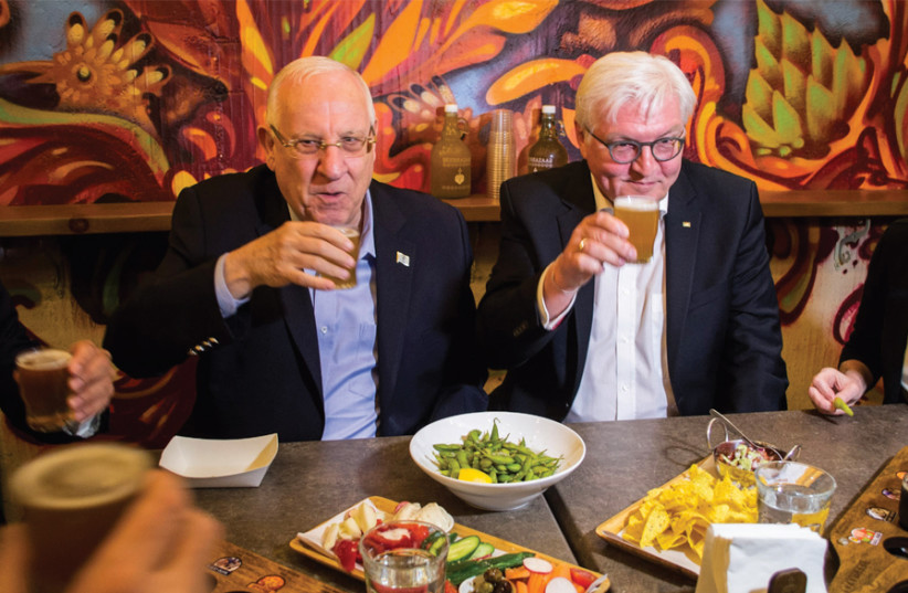 President Reuven Rivlin (l) and German President Frank-Walter Steinmeier raise a glass in the shuk (photo credit: Courtesy)