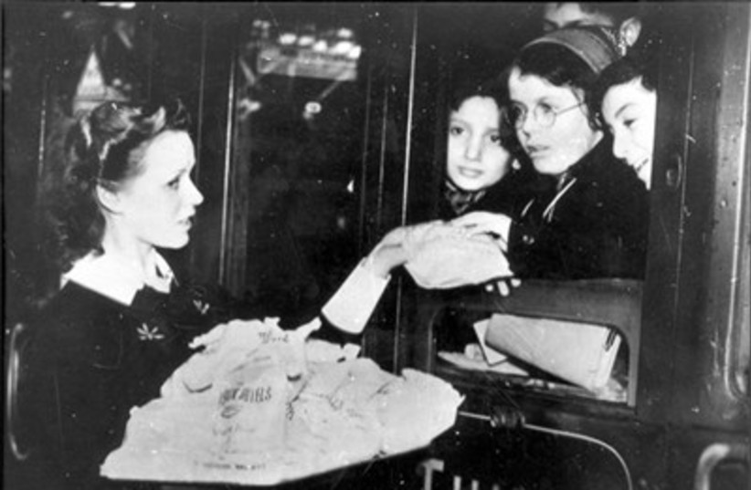Children evacuated from Germany on the Kindertransport in 1938/1939 are given candies in Southampton, England (photo credit: MAARIV)