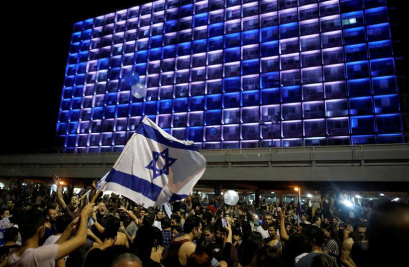 People celebrate the winning of the Eurovision Song Contest 2018 by Israel's Netta Barzilai with her song "Toy" , Rabin square in Tel Aviv, Israel, May 13, 2018. (photo credit: REUTERS/CORINNA KERN)