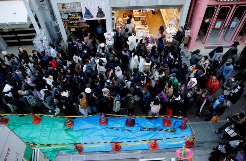 Pedestrians walk past a site where a vehicle ploughed into crowds celebrating New Year's Day in a popular tourist area of Harajuku in Tokyo, Japan, January 1, 2019 (photo credit: REUTERS/KIM KYUNG-HOON)