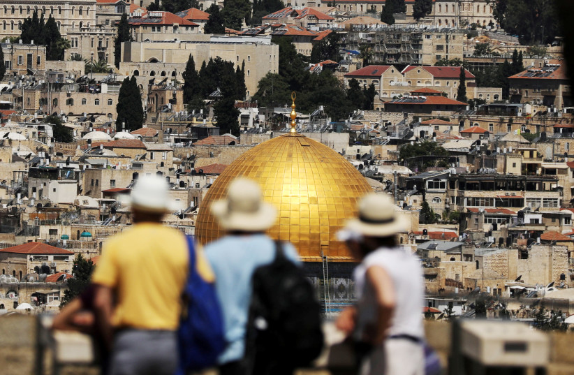 Tourists look at the Dome of the Rock, located in Jerusalem's Old City on the compound known to Muslims as Noble Sanctuary and to Jews as Temple Mount, June 21, 2018 (photo credit: AMMAR AWAD/REUTERS)