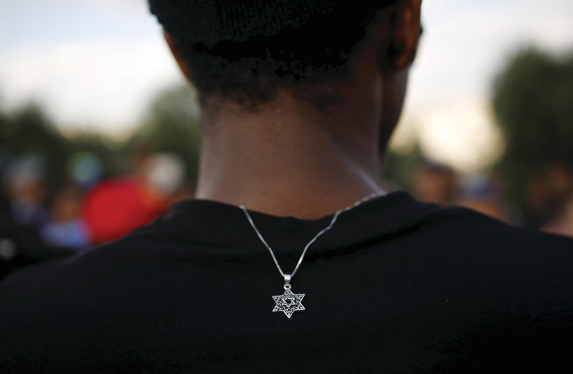 A MEMBER of the Ethiopian Jewish community in Israel wears a medallion with the Star of David as he takes part in a ceremony marking the holiday of Sigd. (photo credit: REUTERS/AMIR COHEN)