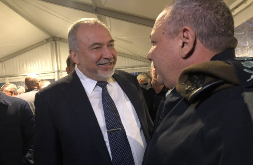 Avigdor Liberman (L) greets Gadi Eisenkot (R) at a ceremony marking the completion of his tenure as IDF chief, January 13th, 2018 (photo credit: ANNA AHRONHEIM)
