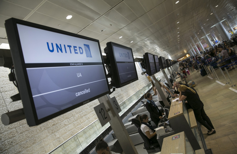 Passengers stand near a check-in desk at Ben Gurion International airport (photo credit: BAZ RATNER/REUTERS)