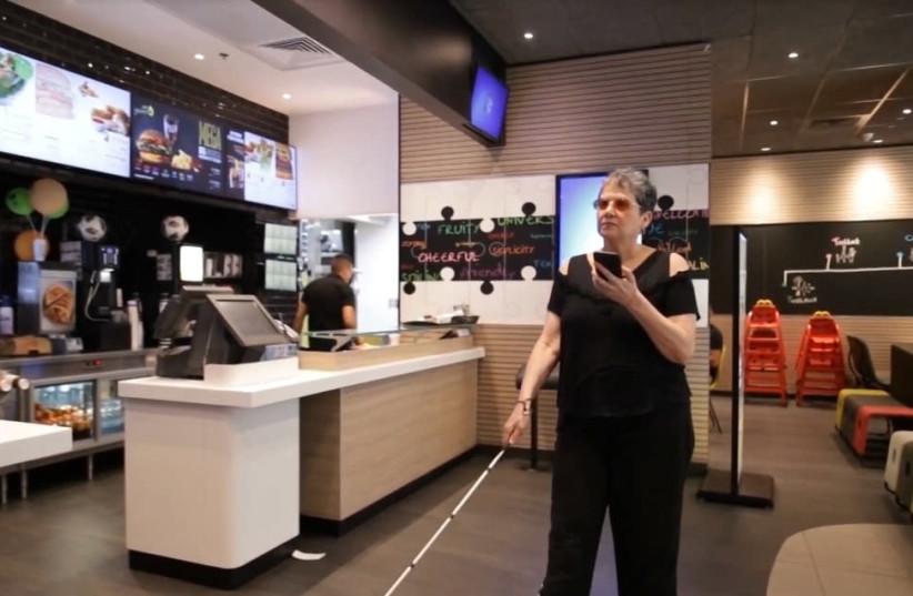A visually impaired woman enters a McDonald's chain restaurant, which has been made accessible to the blind and visually impaired community. (photo credit: Courtesy)