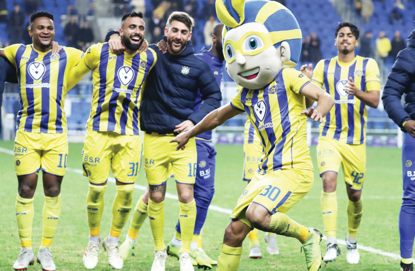 MACCABI TEL AVIV defender Maor Kandil dons the team mascot’s head to entertain his teammates following the yellow-and-blue’s 1-0 victory over Beitar Jerusalem in Premier League action on Monday night (photo credit: DANNY MARON)