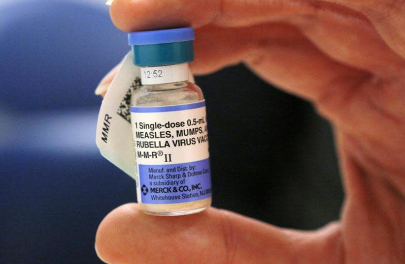 A nurse holds a vial of measles, mumps and rubella vaccine (photo credit: REUTERS/BRIAN SNYDER)