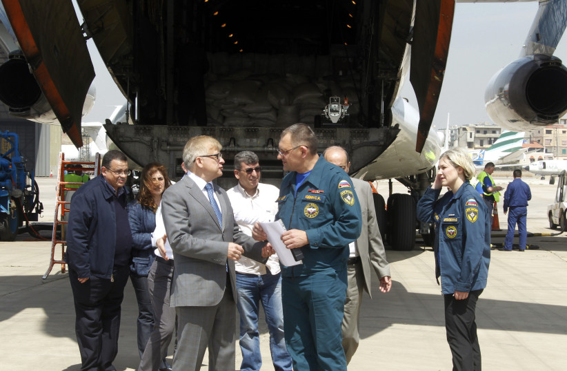 Russian ambassador to Lebanon Alexander Zasypkin (front L) talks with the pilot of a Russian aeroplane that arrived with humanitarian aid for Syrian refugees in Lebanon. (photo credit: REUTERS)