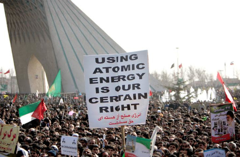  Iranians gather at Azadi (freedom) square to mark the 27th anniversary of Iran's Islamic Revolution, as they carry a placard in support of Iran's nuclear technology in Tehran (photo credit: REUTERS/RAHEB HOMAVANDI)