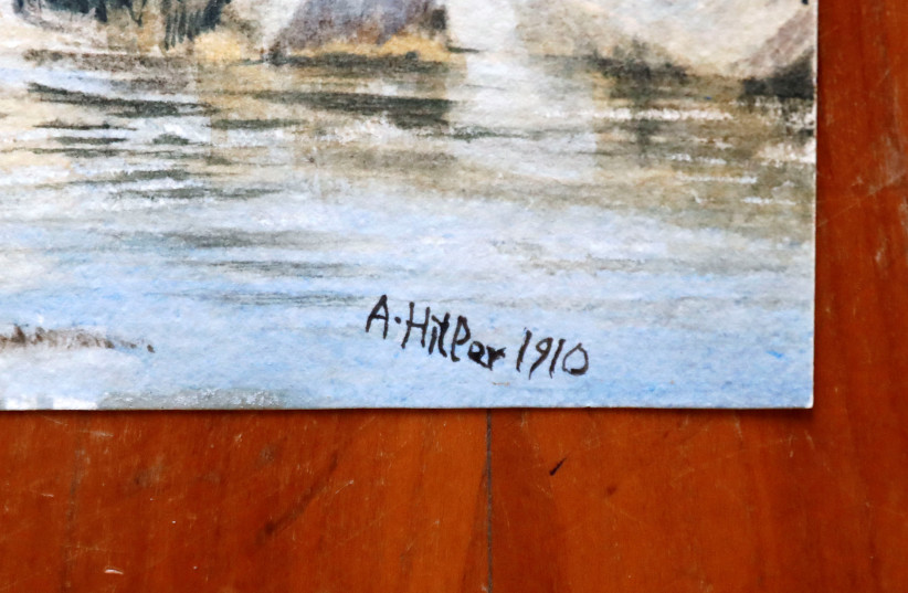 A signature is seen on a watercolour of an unknown landscape attributed to former German dictator Adolf Hitler, before an auction at Kloos house at a starting bid of 4,000 Euro (4,548 US Dollars) in Berlin, Germany, January 24, 2019 (photo credit: FABRIZIO BENSCH / REUTERS)