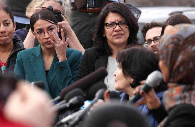 U.S. Representative Alexandria Ocasio-Cortez (D-NY), with Representative Rashida Tlaib (D-MI), wipes away tears as Representative Ilhan Omar (D-MN) talks about her own experience as a refugee during a news conference to call on Congress to cut funding for ICE (Immigration and Customs Enforcement), a (photo credit: REUTERS/JONATHAN ERNST)