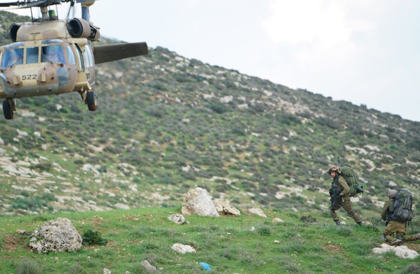 An IDF helicopter and soldiers during a training exercise for the 401th Brigade (photo credit: IDF SPOKESMAN’S UNIT)