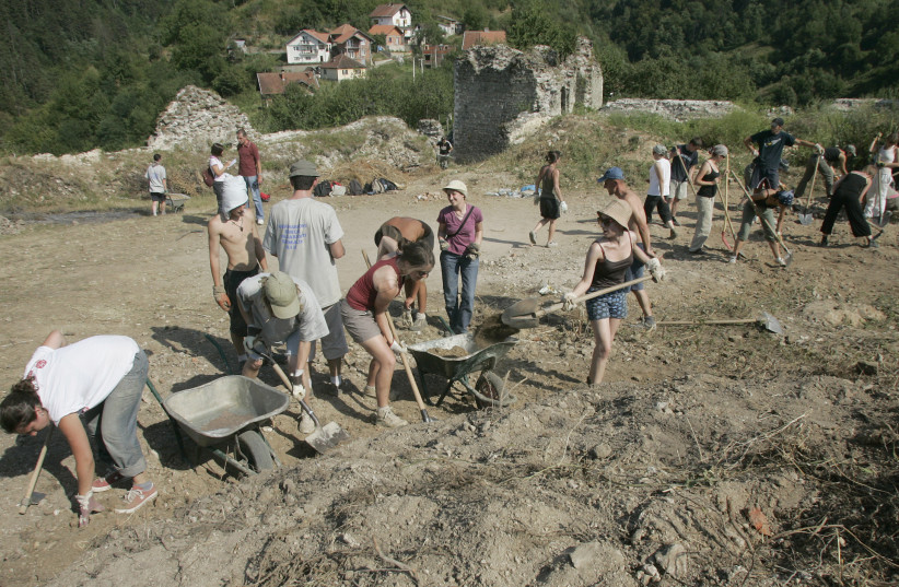 Young volunteers clear earth from a medieval fortress above Srebrenica, Bosnia, in a "voluntourism" program, 2007.  (photo credit: REUTERS/DANILO KRSTANOVIC)