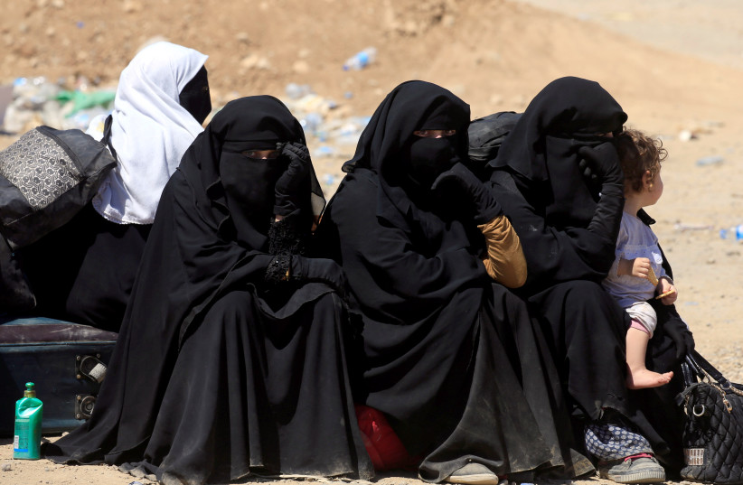 Displaced Iraqi women who fled from clashes sit together during a battle between Iraqi forces and Islamic state militants in western Mosul, Iraq, May 17, 2017 (credit: REUTERS/ ALAA AL-MARJANI)