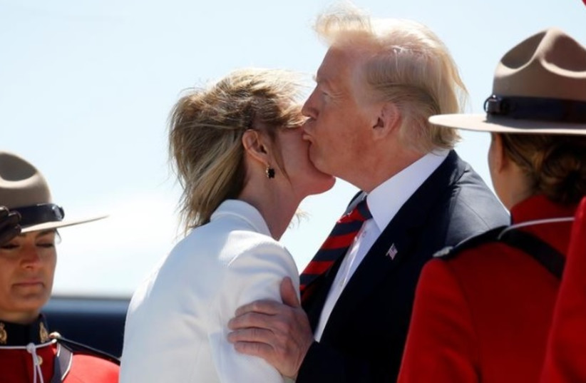 U.S. President Donald Trump kisses U.S. Ambassador to Canada Kelly Knight Craft as he arrives at Canadian Forces Base Bagotville in La Baie, Quebec, Canada, June 8, 2018. (photo credit: LEAH MILLIS/REUTERS)