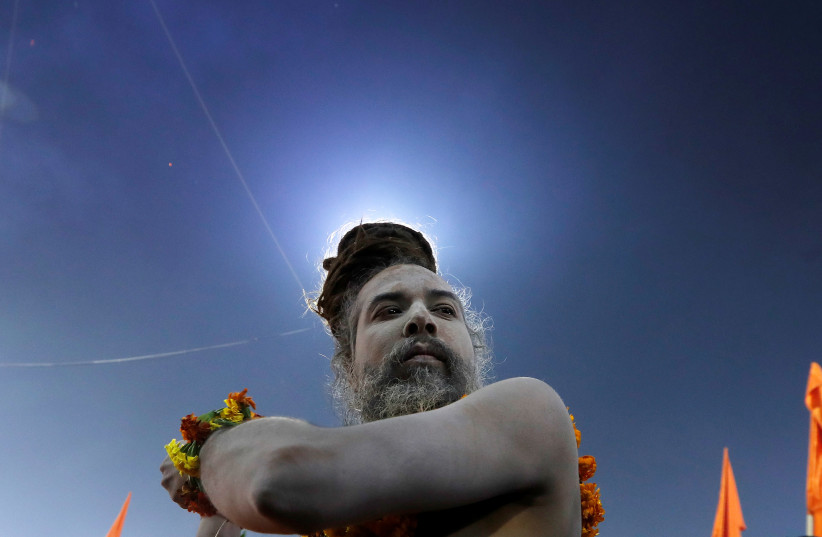 A Naga Sadhu or a Hindu holy man is covered in ashes as he participates in a procession before the second "Shahi Snan" (grand bath) at "Kumbh Mela" or the Pitcher Festival, in Prayagraj, previously known as Allahabad, India, February 4, 2019. (photo credit: ADNAN ABIDI/ REUTERS)