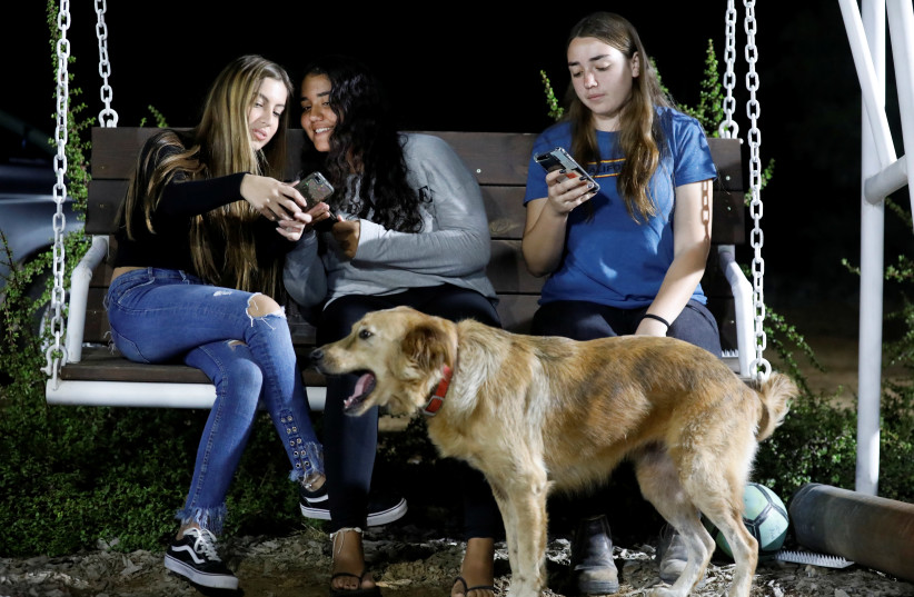 Israeli teens Meshy Elmkies, Liam Yefet and Lee Cohen use their Instagram account @Otef.Gaza, or Gaza Periphery, to share their experiences of life under rocket fire at Kibbutz Kerem Shalom, November 11, 2018 (photo credit: AMIR COHEN/REUTERS)