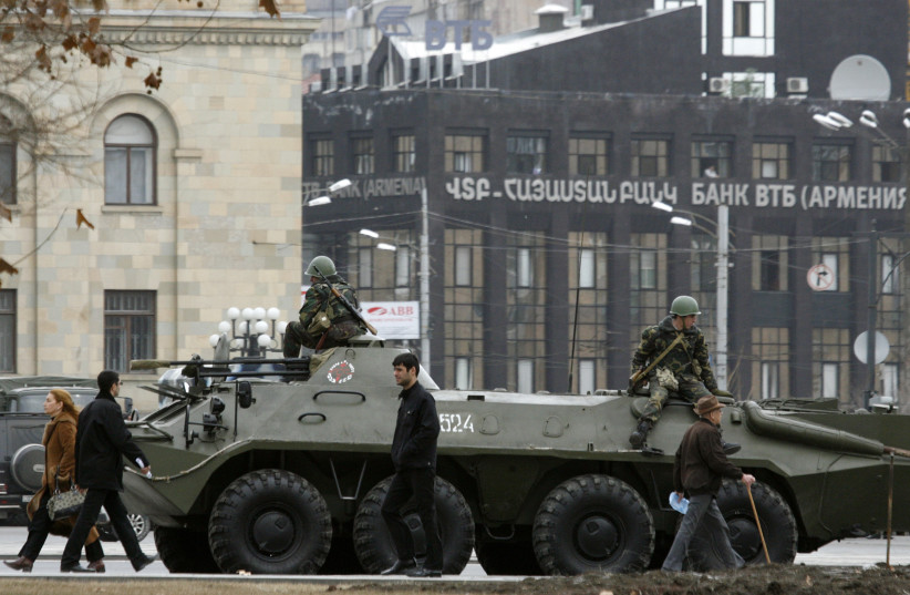 People walk past an armoured vehicle in central Yerevan March 3, 2008. (photo credit: DAVID MDZINARISHVILI/REUTERS)