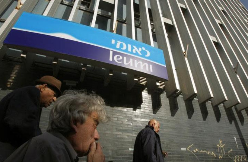 Israelis walk past a branch of Bank Leumi in Tel Aviv (credit: REUTERS/GIL COHEN MAGEN)