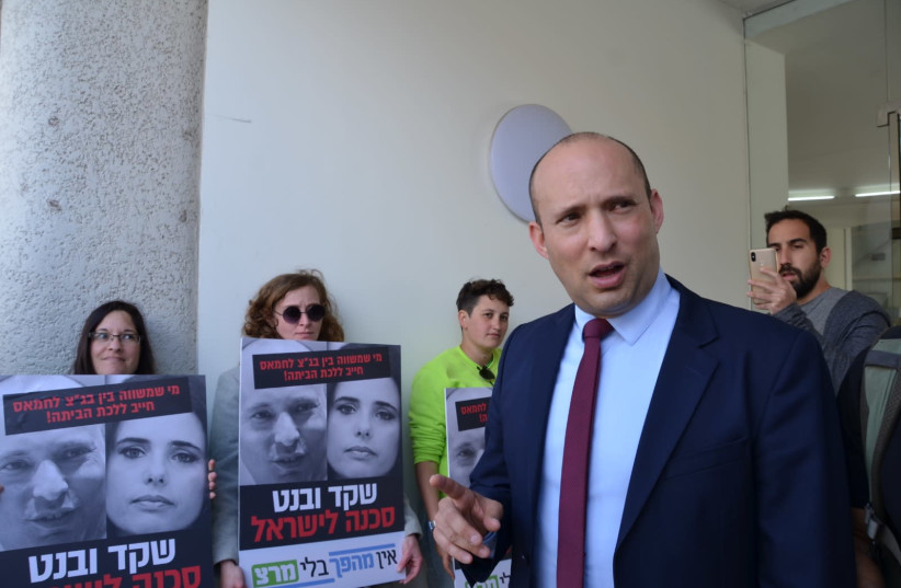 Meretz supporters (background) confront Naftali Bennett (front-right) outside a press conference and call him a "danger to Israel," in Tel Aviv, March 17th, 2019 (photo credit: Courtesy)
