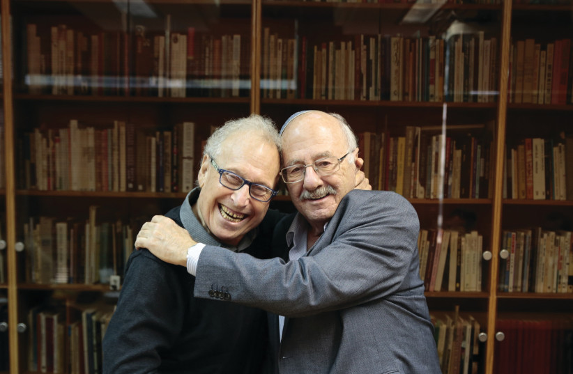 DAN ALMAGOR (left) is embraced by National Library chairman David Blumberg.  (photo credit: FROM THE DEPTHS)