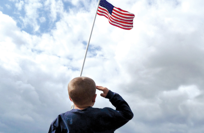 A CHILD salutes the American flag. (photo credit: JEFF TURNER/FLICKR)