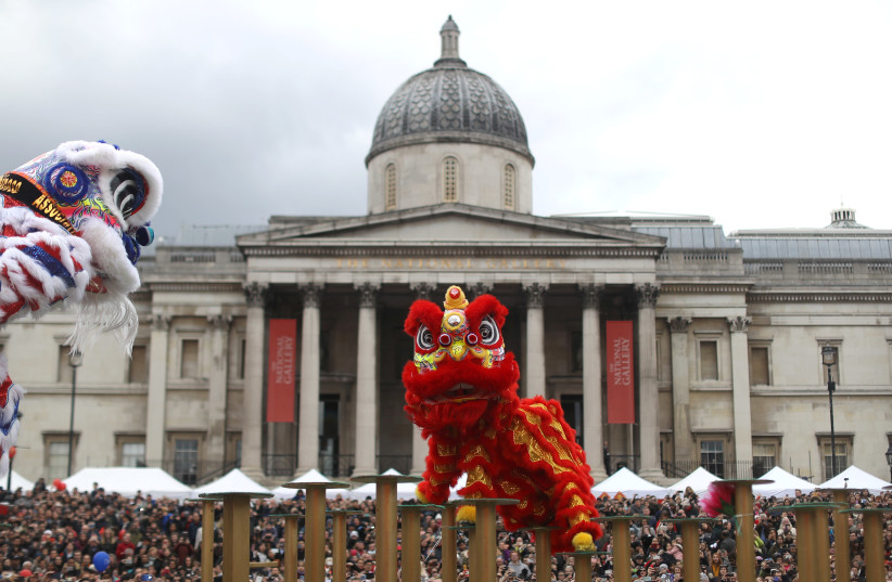 Spectators watch performers dressed in traditional lion and dragon costumes take part in the Chinese New Year parade in front of the National Portrait Gallery in central London, Britain (photo credit: SIMON DAWSON/ REUTERS)
