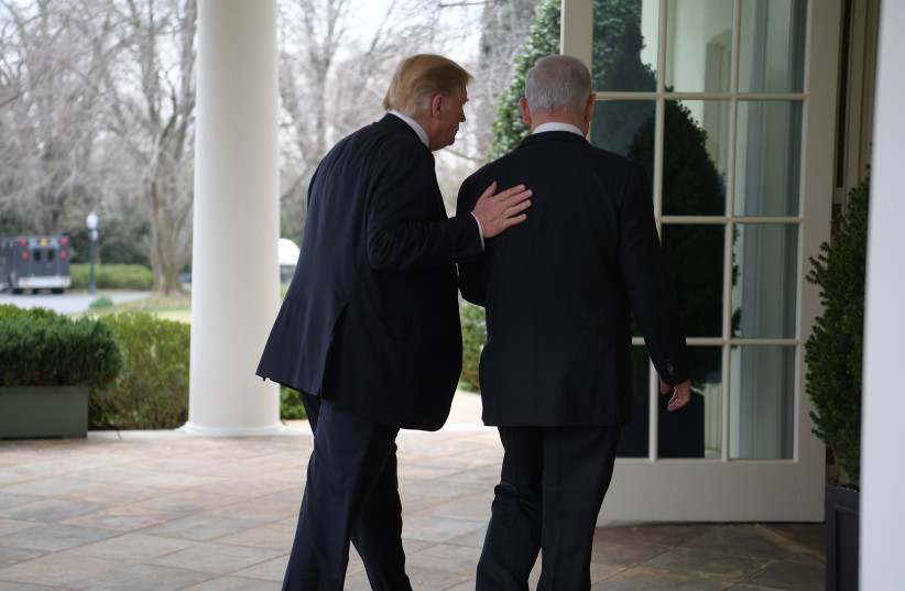 U.S. President Donald Trump (L) puts a hand on the back of Prime Minister Benjamin Netanyahu (R), March 25th, 2019 (photo credit: AMOS BEN-GERSHOM/GPO)
