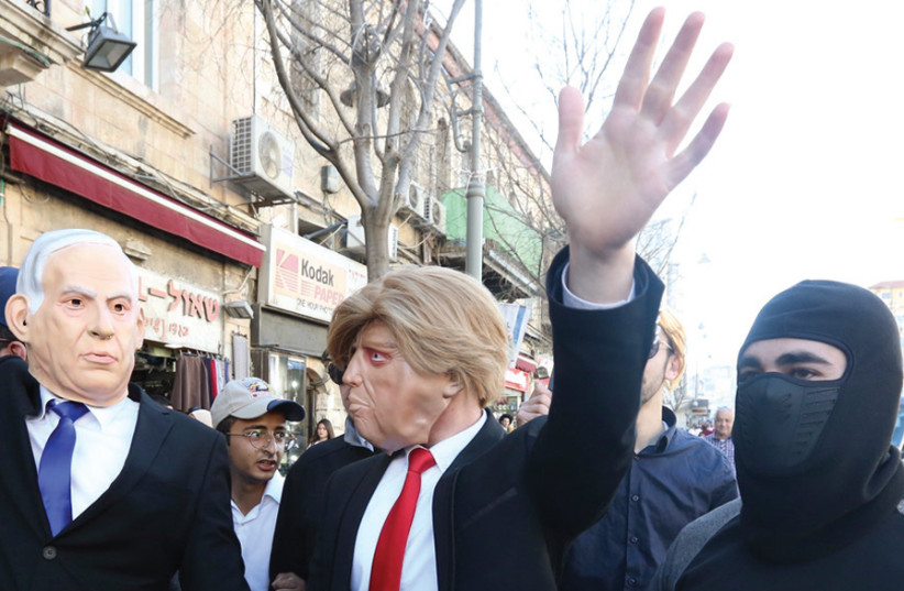 Two men dressed up as Prime Minister Benjamin Netanyahu and US President Donald Trump walk through the streets of Jerusalem for Purim, which was celebrated in the capital on March 22 (photo credit: MARC ISRAEL SELLEM)