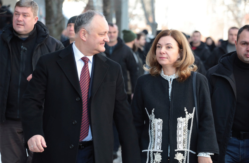 Moldova’s President Igor Dodon and his wife, Galina, walk out of a polling station in Chisinau on February 24 (photo credit: VLADISLAV CULIOMZA / REUTERS)