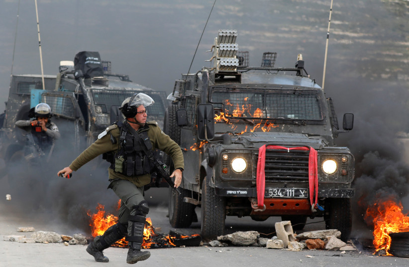 Israeli border police throws tear gas during clashes near Ramallah (REUTERS/Mohamad Torokman) (photo credit: REUTERS/MOHAMAD TOROKMAN)