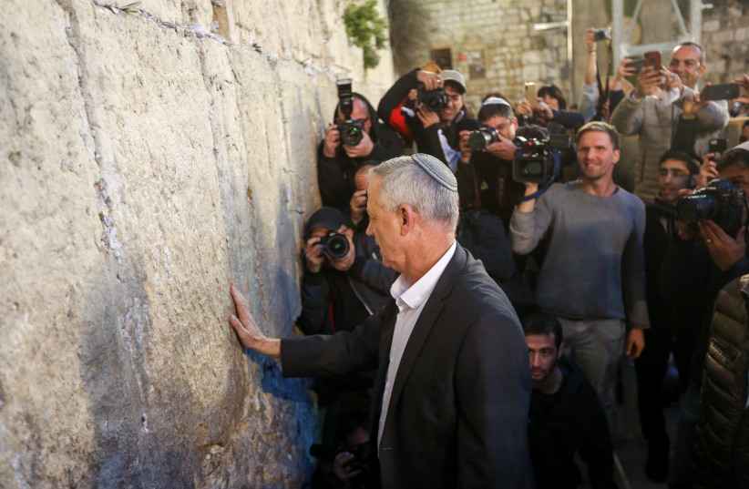 Benny Gantz, chairman of the Blue and White party, places a hand on the Western Wall, March 28th, 2019 (photo credit: MARC ISRAEL SELLEM/THE JERUSALEM POST)