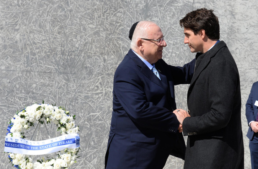 President Rivlin laid a wreath at the Holocaust memorial in Ottawa, accompanied by Prime Minister Trudeau (photo credit: Mark Neiman/GPO)