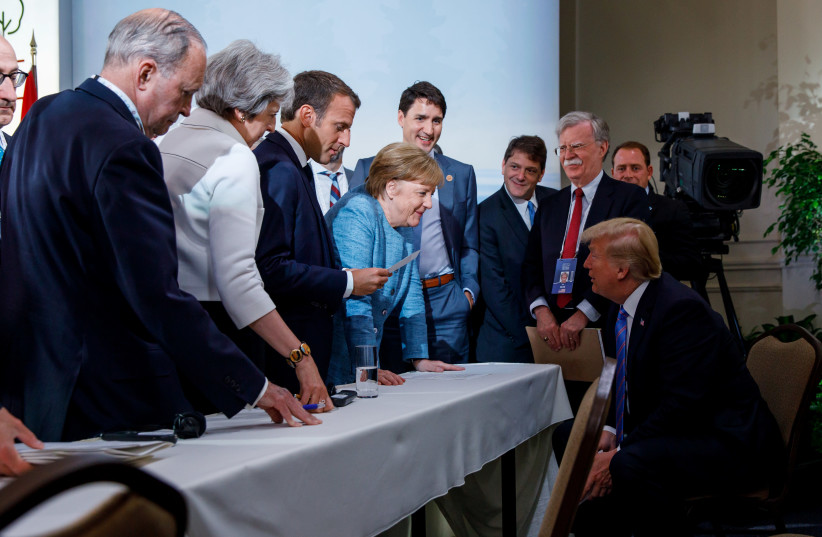 Canada's Prime Minister Justin Trudeau and G7 leaders Britain's Prime Minister Theresa May, France's President Emmanuel Macron, Germany's Chancellor Angela Merkel, and U.S. President Donald Trump discuss the joint communique following a breakfast meeting on the second day of the G7 meeting in Charle (photo credit: REUTERS)