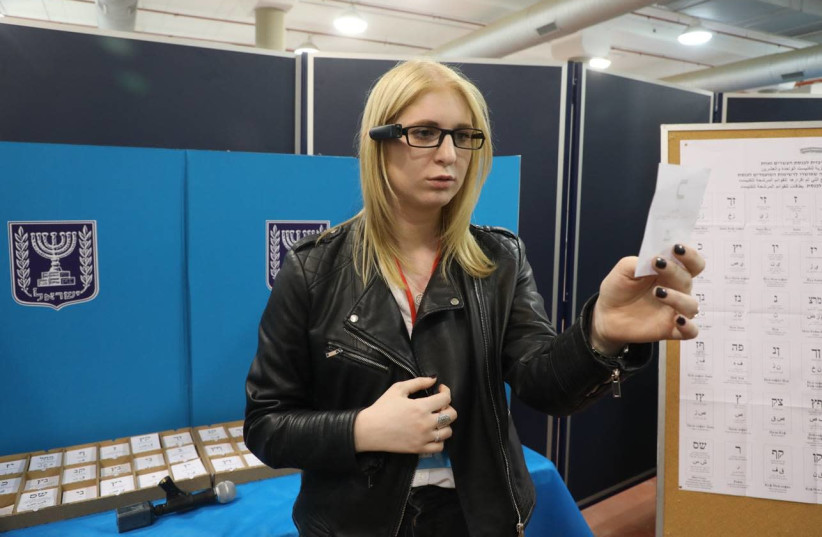 A visually-impaired OrCam user demonstrates using the technology to vote (credit: ORCAM PR)