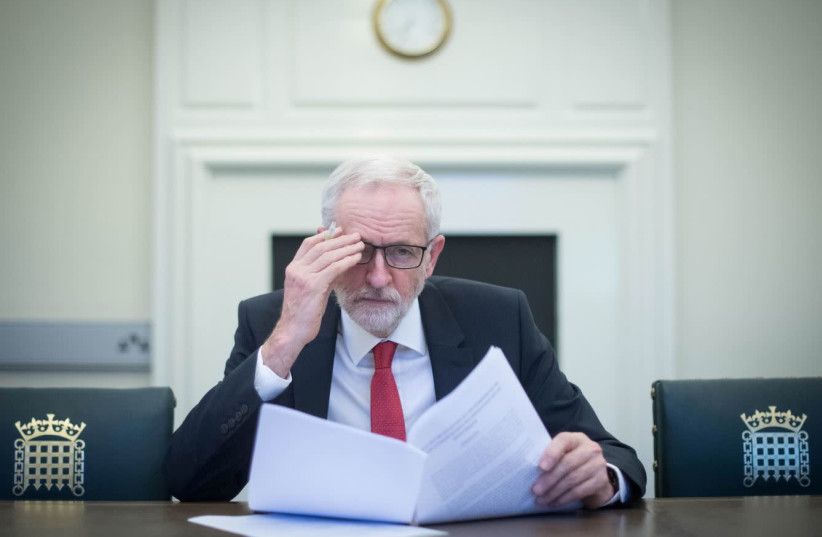 British opposition Labour Party leader Jeremy Corbyn holds the Political Declaration, setting out the framework for the future UK-EU relations, at his office in the Houses of Parliament in London, Britain April 2, 2019. (photo credit: STEFAN ROUSSEAU/REUTERS)