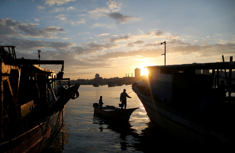 The sun rises as fishermen are seen at the seaport of Gaza City, April 2, 2019 (photo credit: SUHAIB SALEM/REUTERS)