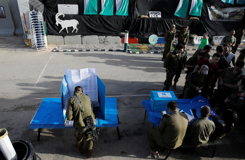 A general view shows Israeli soldiers voting at a mobile voting booth, two days before polling stations open in the rest of Israel, at a military post outside the northern Gaza Strip, in southern Israel April 7, 2019 (photo credit: AMIR COHEN/REUTERS)