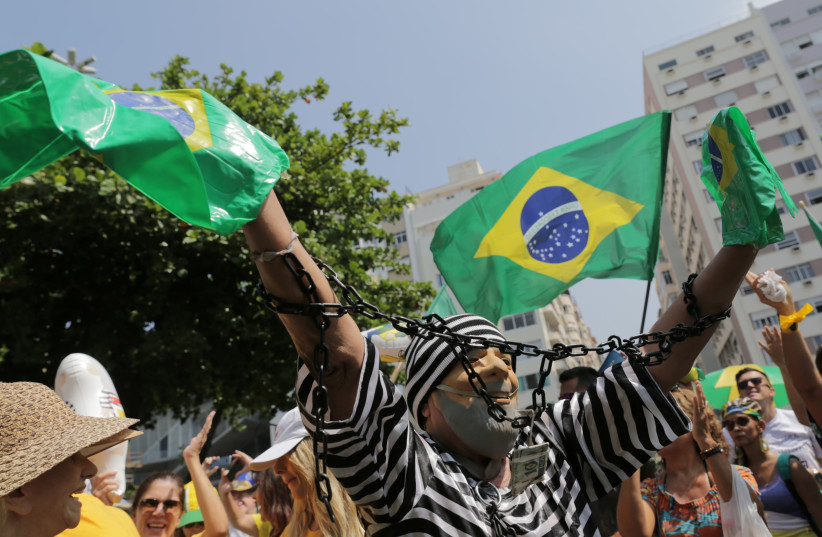 A demonstrator wearing a costume representing Brazil's former President Luiz Inacio Lula da Silva as a prisoner, attends a protest against corruption and in favour of the "Car Wash" corruption investigation, in Rio de Janeiro, Brazil April 7, 2019 (photo credit: REUTERS)