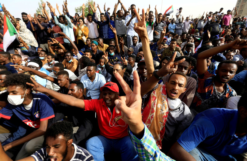 Sudanese demonstrators cheer as they attend a protest rally demanding Sudanese President Omar Al-Bashir to step down outside the Defence Ministry in Khartoum, Sudan April 11, 2019 (photo credit: STRINGER/ REUTERS)