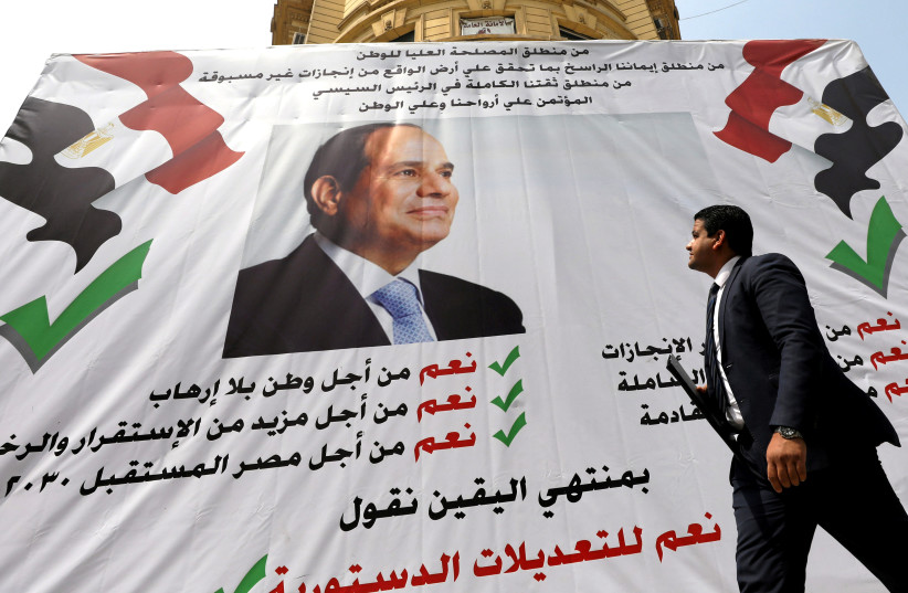 A man walks in front of a banner reading, "Yes to the constitutional amendments, for a better future", with a photo of the Egyptian President Abdel Fattah al-Sisi before the approaching referendum on constitutional amendments in Cairo, Egypt April 16, 2019.  (photo credit: MOHAMED ABD EL GHANY/ REUTERS)