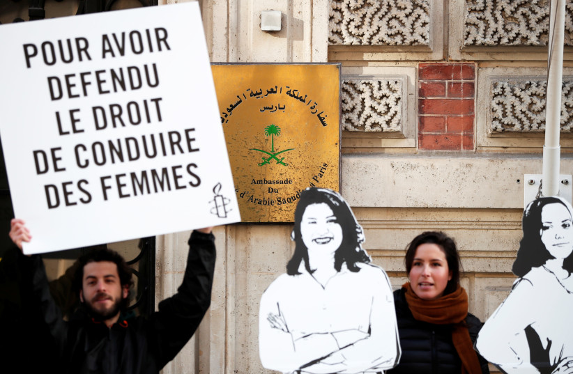 Demonstrators from Amnesty International hold placards outside the Saudi Arabian Embassy to protest on International Women's day to urge Saudi authorities to release jailed women's rights activists Loujain al-Hathloul, Eman al-Nafjan and Aziza al-Yousef in Paris, France, March 8, 2019. The placard r (photo credit: BENOIT TESSIER /REUTERS)