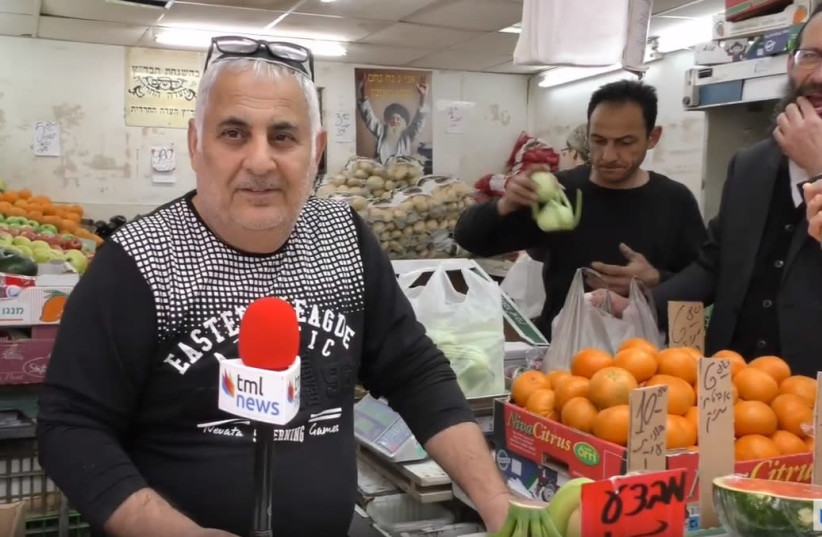 A shopkeeper in Jerusalem's Mahane Yehuda market, April 2019 (photo credit: THE MEDIA LINE)