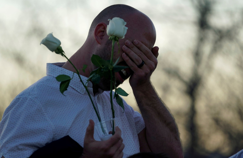 Will Beck, a survivor of the attack at Columbine high school, cries on arrival at the Columbine memorial a day before the school shooting's 20th anniversary, in Littleton, Colorado, U.S., April 19, 2019 (photo credit: RICK WILKING / REUTERS)