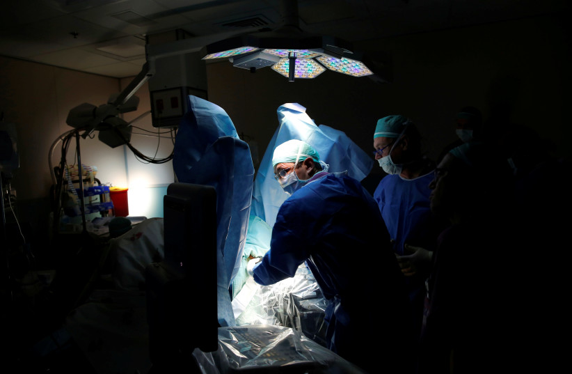 Doctors performing surgery (photo credit: BAZ RATNER/REUTERS)