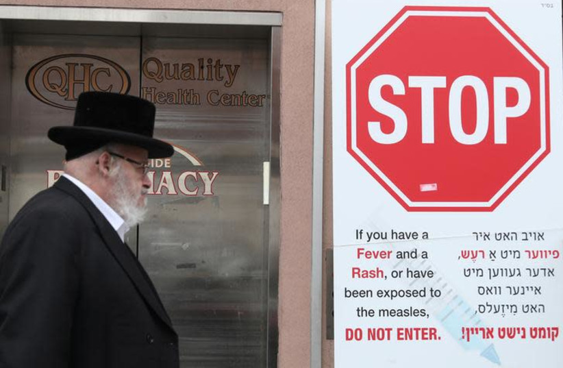 A sign warning people of measles in the ultra-Orthodox Jewish community of Williamsburg is seen in New York (photo credit: REUTERS/SHANNON STAPLETON)