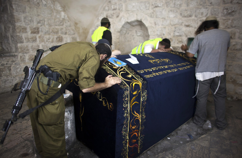 An Israeli soldier prays together with other worshippers inside Joseph's Tomb in the West Bank (photo credit: NIR ELIAS / REUTERS)