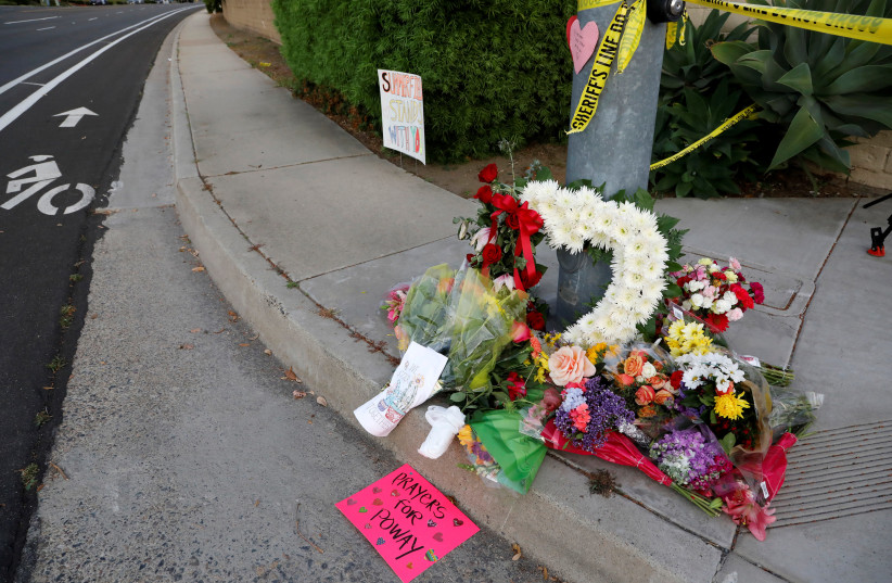 A makeshift memorial was placed by a light pole a block away from a shooting incident where one person was killed at the Congregation Chabad synagogue in Poway, north of San Diego, California. (photo credit: JOHN GASTALDO/REUTERS)