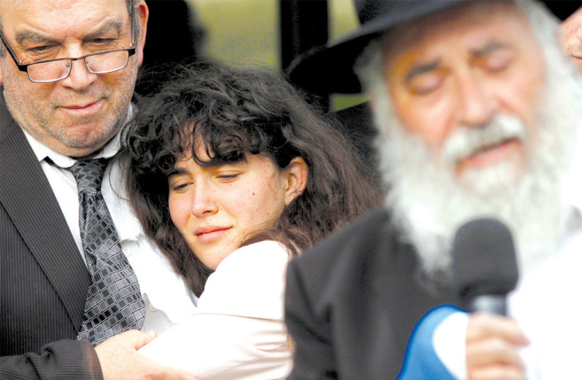 HOWARD KAYE holds daughter Hannah Jacqueline Kaye at the funeral for their wife and mother Lori Gilbert- Kaye on April 29, the sole fatality of the shooting at Congregation Chabad synagogue in Poway, north of San Diego. Speaking at front is Rabbi Yisroel Goldstein, who is said to have been shielded  (credit: REUTERS)
