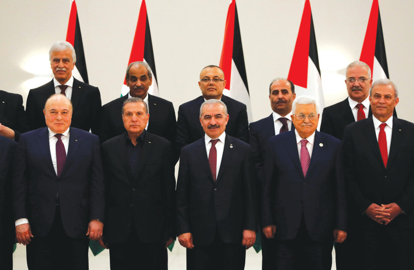 PALESTINIAN AUTHORITY PRESIDENT Mahmoud Abbas, Prime Minister Mohammad Shtayyeh (third left) and other members of the new government attend the swearing-in ceremony in Ramallah last month. (photo credit: MOHAMAD TOROKMAN/REUTERS)